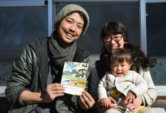 「里山ごはんのがっこう」のチラシを持つ君島さん夫婦