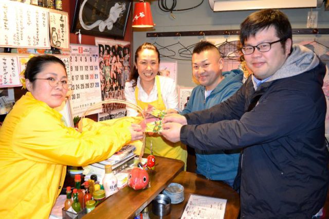 来客らに黄ぶなグッズを手渡す屋台横丁のメンバー