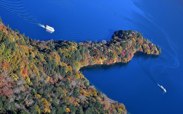群青色の湖面に際立つ八丁出島の紅葉＝２６日午前９時、日光市中宮祠