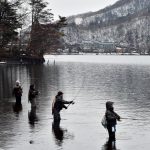 雪が残る中禅寺湖で釣りを楽しむ人たち