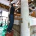 陽明門の逆柱に胡粉を塗る作業員＝２７日午前９時４５分、日光市山内の日光東照宮